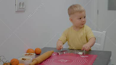 Little boy enjoys playing with kitchen utensils while mom cooks