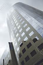 Modern corporate high rise building with reflective glass windows and contemporary urban architecture exterior design