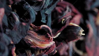 Stream of dry red hibiscus petals slowly rotating before the camera. Concept of
