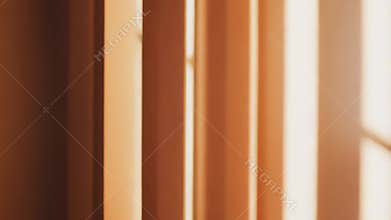 Blinds casting shadows with warm sunlight