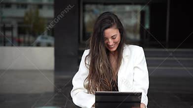 A young woman engaged with her tablet in a vibrant urban setting, representing modern life