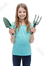 Smiling little girl with rake and scoop