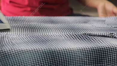 Hand of woman ironing cloth.