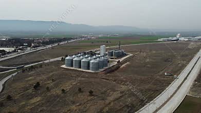 Aerial view of farm grain silo in wide agricultural field