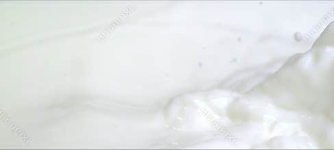 Slow motion almonds falling into milk. Milky splash