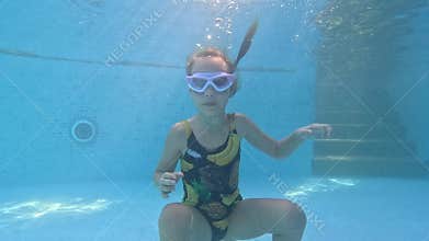 A little girl dives underwater for a toy