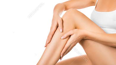 Woman applying moisturizer on her perfect legs, isolated on white background. Skin and body care concept