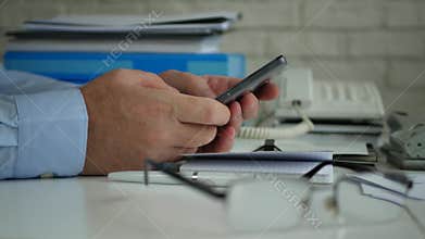 Businessman in Accounting Office Text Using Cellphone Wireless Communication