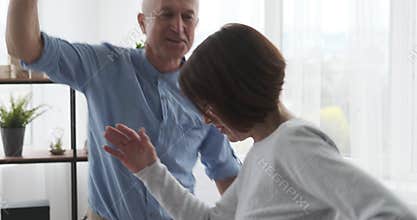 Elderly couple dancing together at home