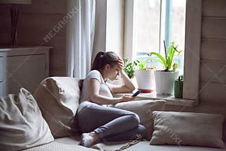 Woman upset after reading bad message on phone at home