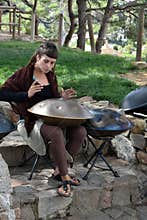 Young woman playing hang instrument