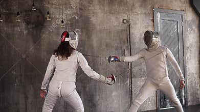 Rivals are actively engaged in fencing a man and a woman are cheating each other