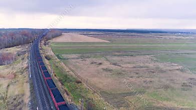 An aerial camera follows a freight train with coal on the move.