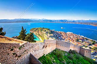 Old town of Nafplion in Greece view from above with tiled roofs, small port and bourtzi castle on the Mediterranean sea.