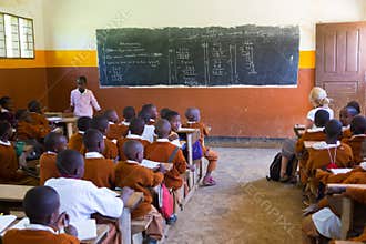 Children in uniforms in primary school classroom listetning to teacher in rural area near Arusha, Tanzania, Africa.