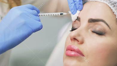 Beautician makes botox injection in the forehead