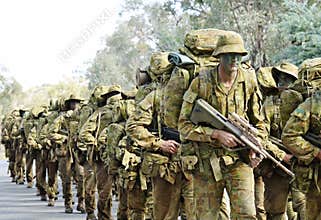 Australian army soldiers marching road to base in camouflage bush war tactics training