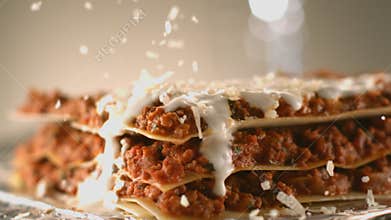 Appetizing meat lasagna is sprinkled with pieces of grated cheese. Parmesan.Very beautiful studio shot. Camera Phanto