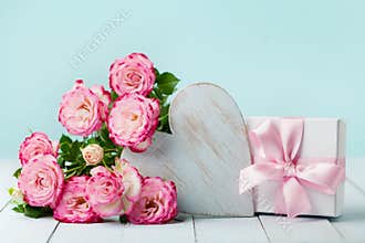 Gift or present box, pink flowers and wooden heart on vintage table. Greeting card for Birthday, Woman or Mothers Day. Pastel.
