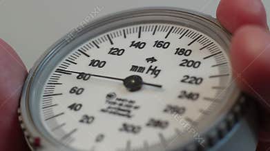Extreme close-up nurse measures blood pressure with sphygmometer