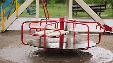 Empty merry go round carousel is wet in the rain, turns lonely in wind. a heavy rain, downpour with a strong wind. large