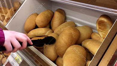Motion of woman selecting bread on bulk food section inside superstore