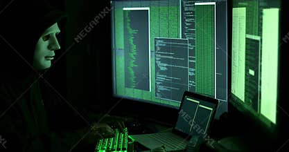 Anonymous man hacking computers in dark room