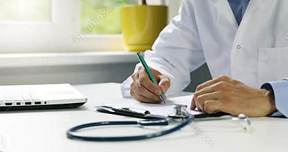 Doctor working at desk in clinics office