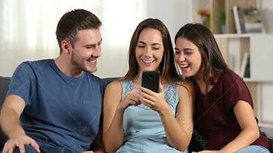 Friends talking about phone content at home