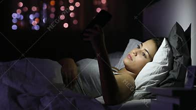 Serious girl browsing phone content in the night