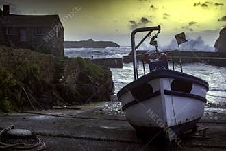 Waves break over the harbour wall