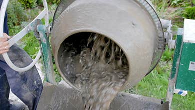Concrete pouring. Construction worker mixing mortar. Pouring concrete mix from cement mixer. The construction process