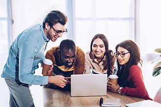 portrait of smiling multicultural business people working on laptop together