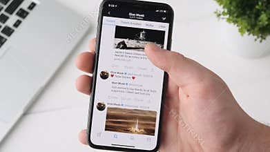 Yekaterinburg, Russia - October 3, 2018: Man using Twitter app on iPhone X smartphone, browsing through Elon Musk`s page