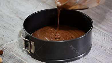 Pouring chocolate cake batter into the baking form. Making Chocolate Brownie.