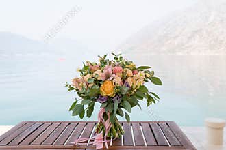 Pink and peach wedding bouquet is on the table