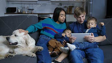 Family with pet dog browsing online on tablet pc