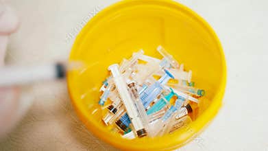 Container with needles from syringes for processing