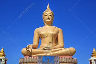 Beautiful of golden Big Buddha against blue sky background in Sing Buri, Thailand