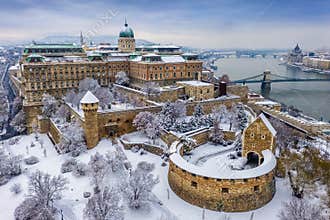 Budapest, Hungary - Aerial view of the snowy Buda Castle Royal Palace from above with the Szechenyi Chain Bridge and Parliament