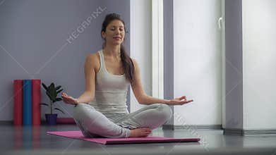 Yoga girl meditating and making a zen symbol with her hand.