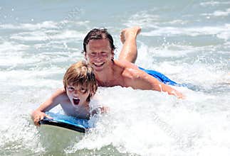 Young father and son learning to surf