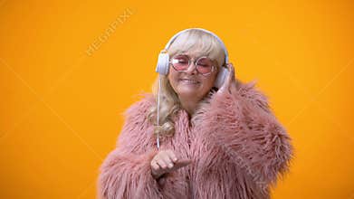 Funny childish aged lady in cute outfit pretending to be DJ, hobby and dreams