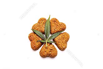 Dog treats and cannabis leaves isolated over white background