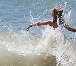 Girl Splashing through Wave