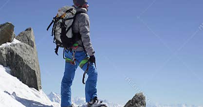 Climber mountaineer man reaching snowy mount top with ice axe in sunny day. Mountaineering ski activity. Skier people