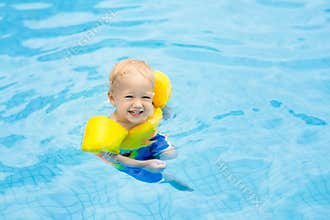 Baby in swimming pool. Kids swim.