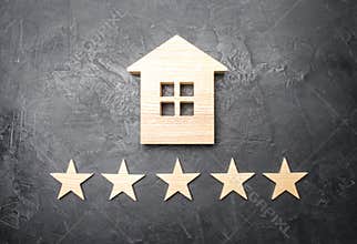 Wooden house and five stars on a gray background. Rating of houses and private property. Buying and selling, renting apartments