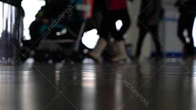 People walking through an airport terminal with suitcases, bags and baggage