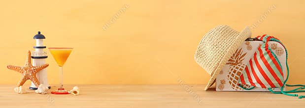 Vacation and summer banner with sea life style objects and bikini over wooden table.